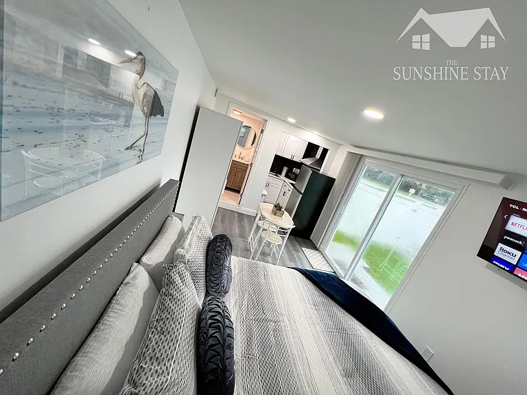 Comfortable queen-size bed with beautiful pillows, TV, and excellent lighting.