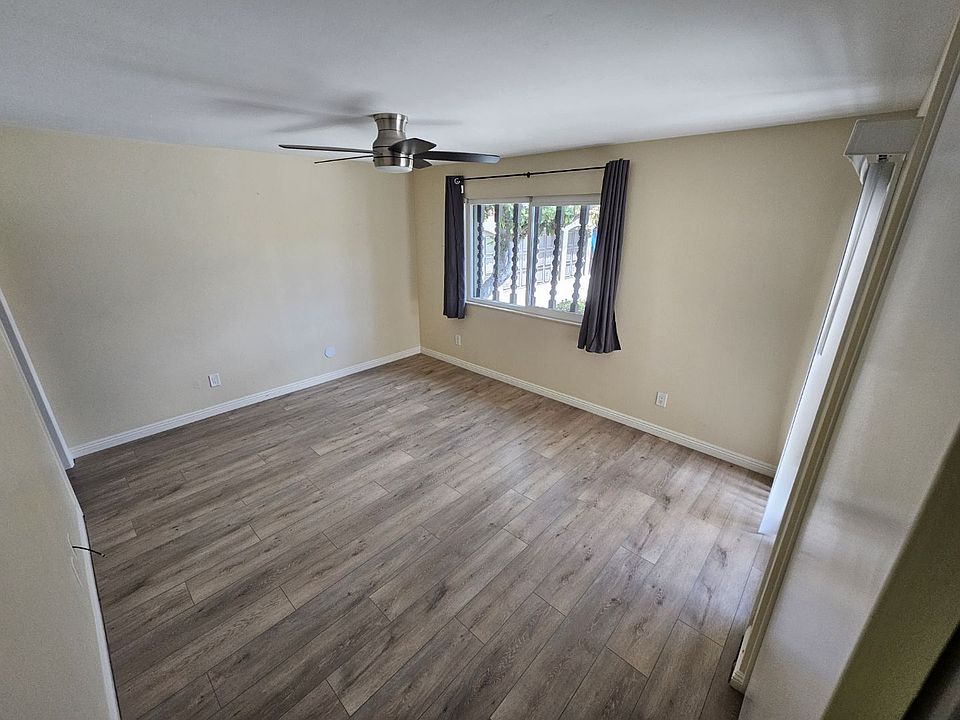 Master bedroom, with ceiling fan, sliding door to patio, and new flooring.