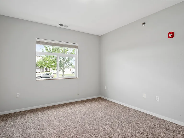 Bright, empty room with a large window, new carpet, and neutral walls, perfect for personalization and ample natural light. Bright, empty room with a large window, new carpet, and neutral walls, perfect for personalization and ample natural light.