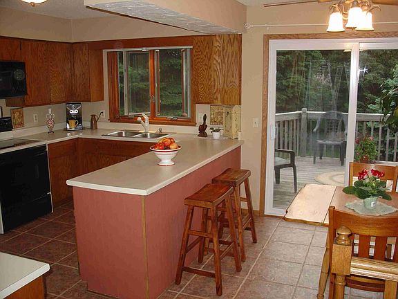 Kitchen offers desk niche and dinette with serene views.
