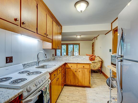 Kitchen with ice-white granite counter tops, GE Hotpoint stove, LG refridgerator and ample cabinet space.