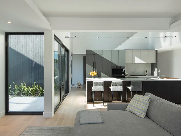 The main living space blends premium finishes, generous natural light, and easy pool access for a turnkey executive rental experience.