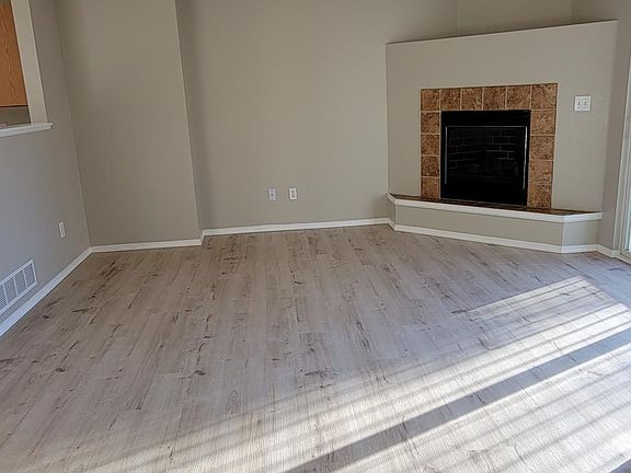 Spacious living room featuring gas fireplace and adjacent patio