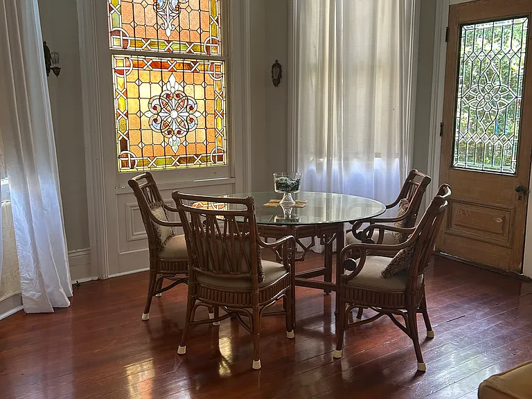 Sitting area in very large family room, stain glass window, beveled door glass, hardwood floors, floor to ceiling windows