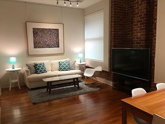 Open living room with 10-foot high ceilings and brick nook