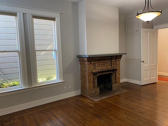 Bedroom 1 with large decorative fireplace and windows. Also has a large double closet.
