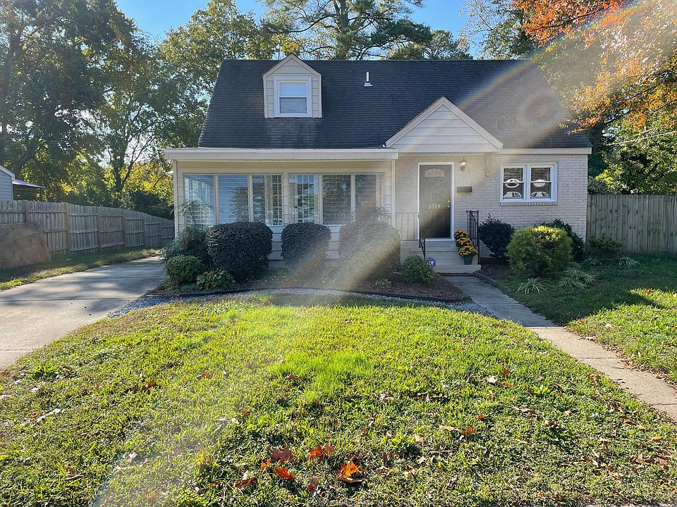 Front of house with driveway on left to detached garage on back of property.