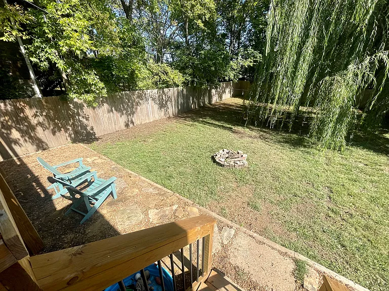 Fully fenced backyard. Weeping willow tree. Firepit.