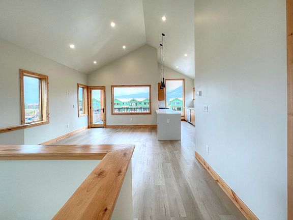 Bedroom/bathroom hall leading to the open living space and kitchen on the second floor