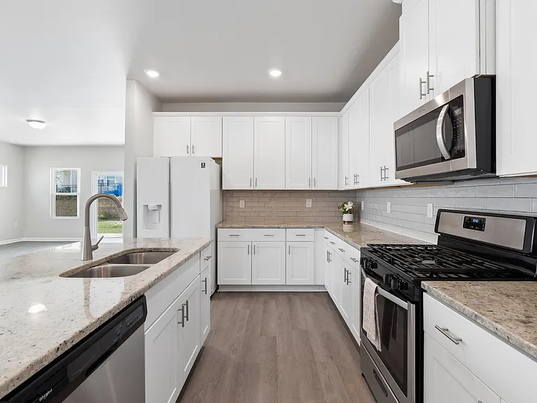 Kitchen with gas oven and large cabinets and large double door refrigerator