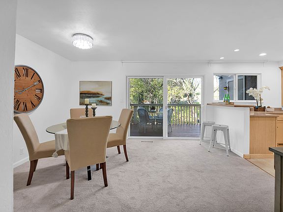 Kitchen/dining area with large sliding doors leading to private deck that has extra storage space and room for BBQ and entertaining.