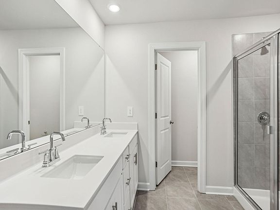 Your primary bathroom features a walk-in closet and double-sink vanity with an oversized mirror.