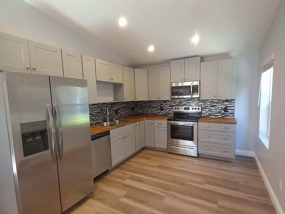 Beautiful kitchen with new stainless steel appliances, butcher block counter tops, stunning tile backsplash and plenty of cabinet space.