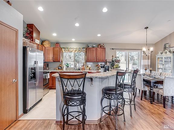 Kitchen, eating bar and dining room displaying beautiful floor. 