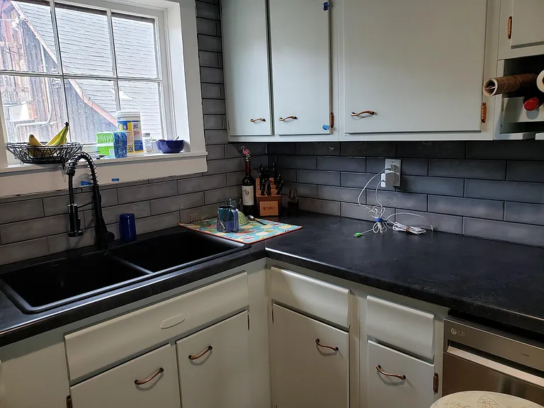 The kitchen features vintage copper pulls, newer stainless appliances, including a dishwasher, and cute built in wine and spice racks!