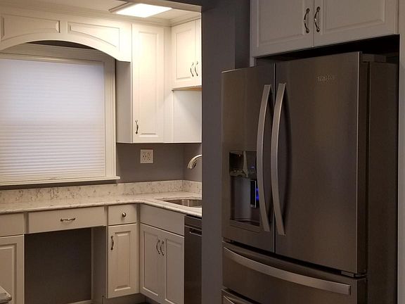 Tucked in view of the sink and dishwasher area, as well as new stainless steel refrigerator/freezer, taken from the open concept dining area.