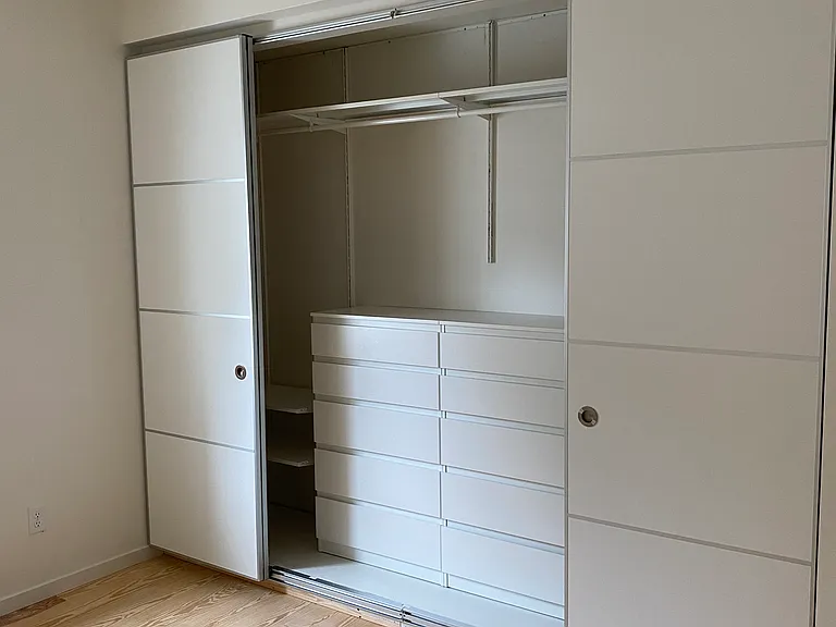 Closet in master bedroom. Built in shelves on both the top of and on both sides of two side-by-side sets of drawers. The same closet system, with same dimensions, is in the second bedroom.