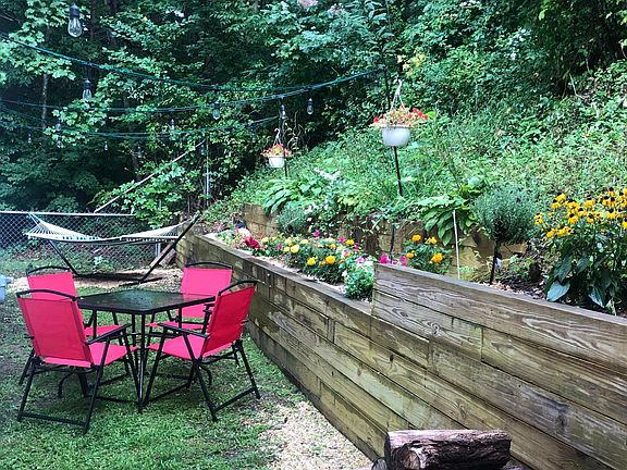 Fenced in hillside courtyard table, bistro lights, hammock