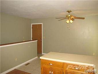 Looking from kitchen toward basement steps and garage door.