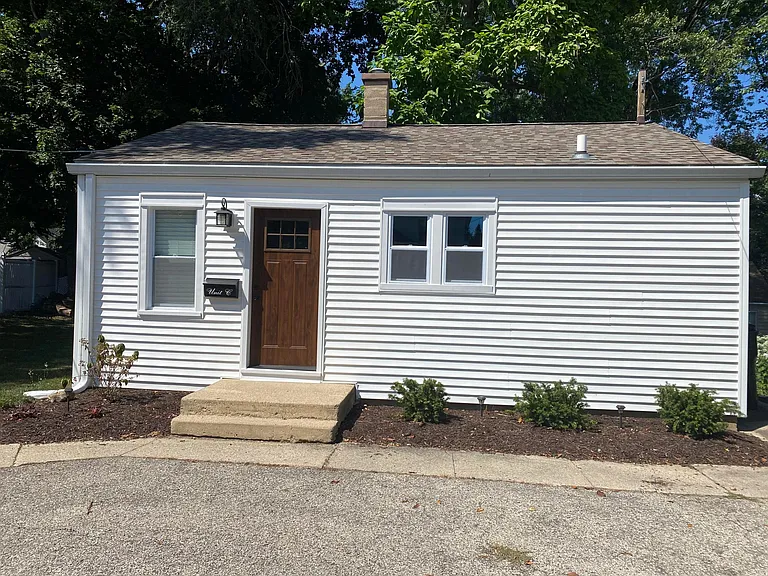 Front of cottage, set back from property with spacious backyard