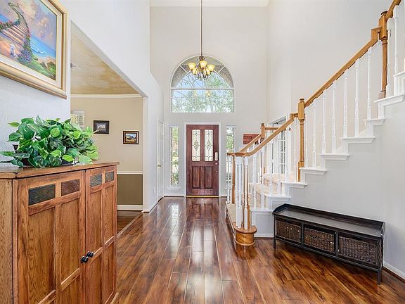 Lovely entryway with wood flooring, curved staircase and 2 story ceiling.