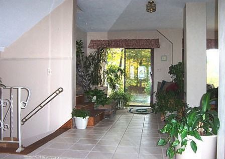 Tiled sunfilled foyer w/ bubbling waterfall and bench for relaxing