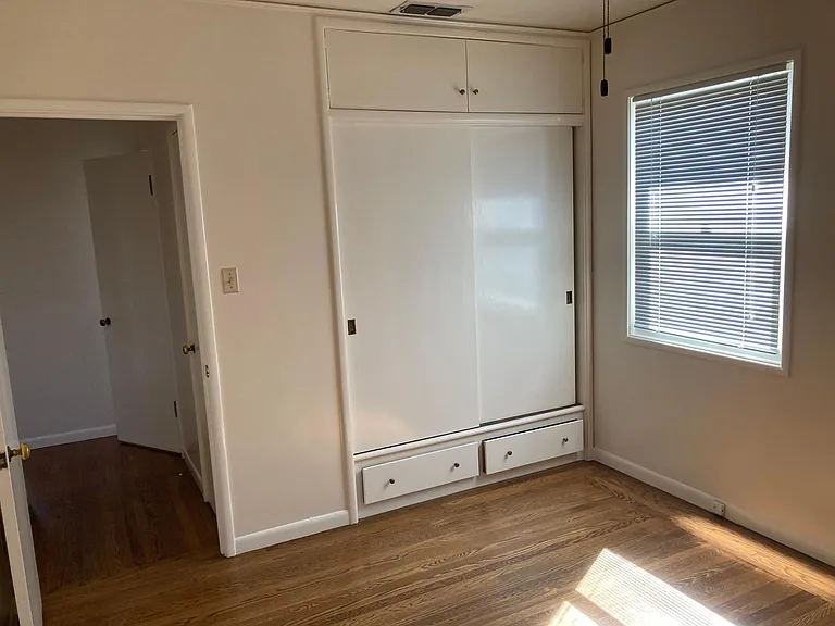 large closet with storage in back bedroom