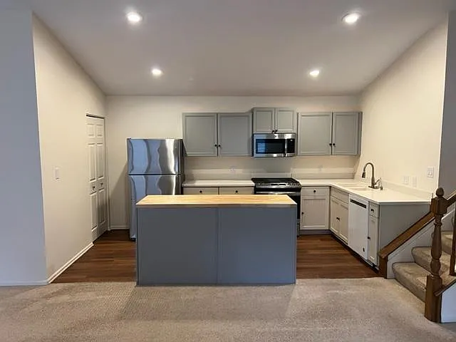 Open plan kitchen with island, pantry and newer SS appliances