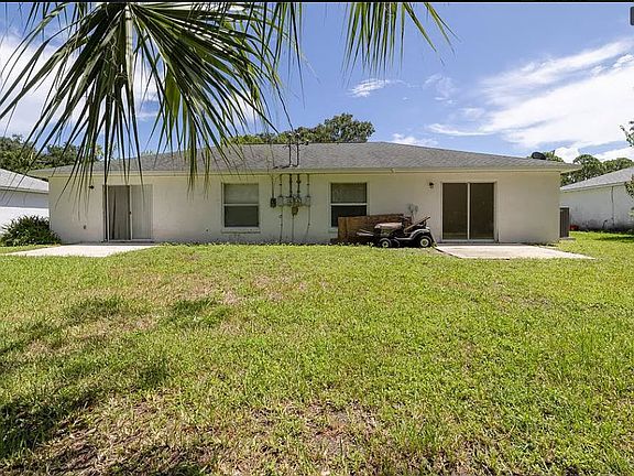 Open backyard and separate concrete patios with sliding door access
