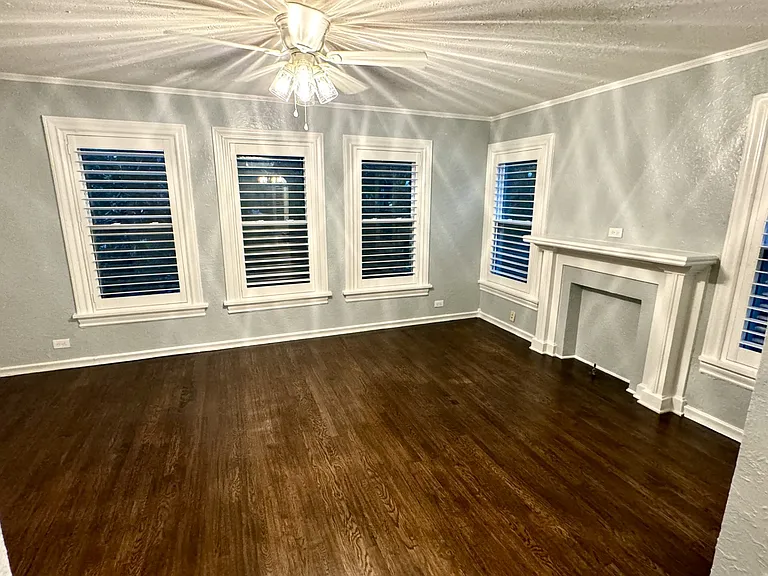 Dining room with feaux fireplace, beautiful hand scraped hard wood floors and plantation wood shutters.