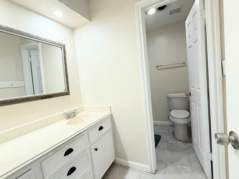 Secondary bathroom with oversized vanity, plenty of storage, and a modern walk-in glass shower.