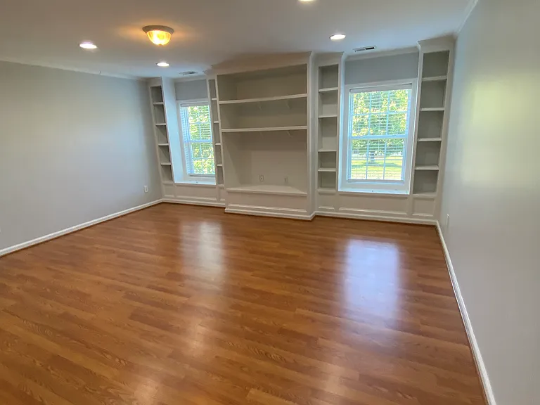 The upstairs entertainment room features 2 reading nooks by the windows and hidden storage spaces beneath. Further storage is found in the closet on the opposite side of the room.