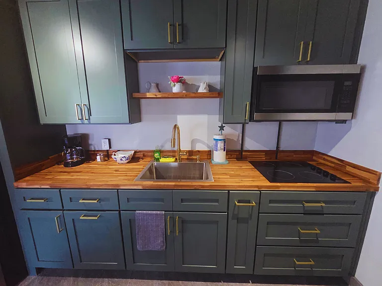 Fully equipped kitchen with a fridge, coffee maker, microwave, and essentials.