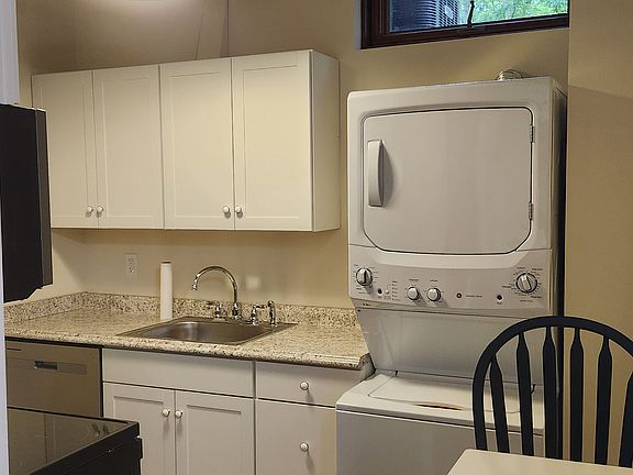 Brand new kitchen with stackable washer and dryer with fold up table.