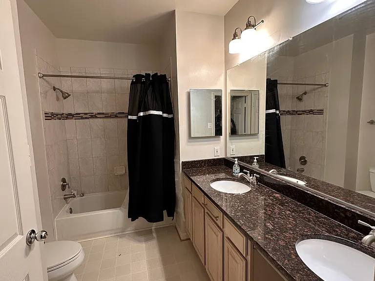 Master bedroom's bathroom with double sink and a bathtub