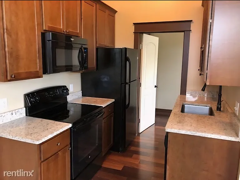 The kitchen includes a stainless steel sink with a garbage disposal, Oven/range, microwave, refrigerator/freezer, wood quiet- close cabnetry