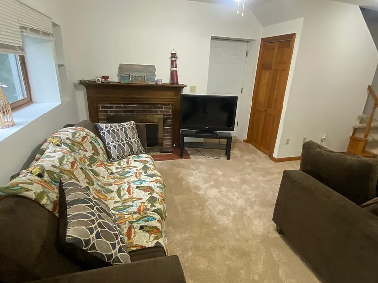 Living room with decorative fireplace and newer carpet.