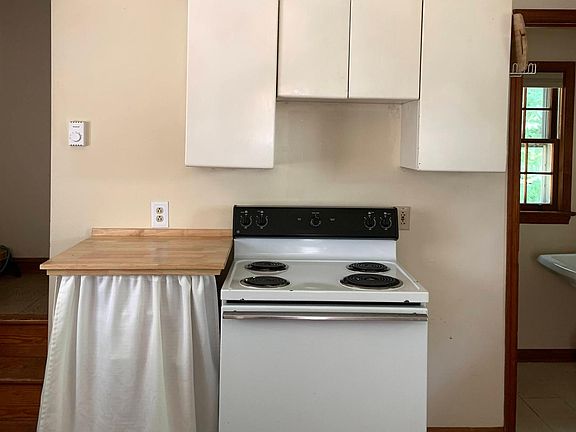 This is the rest of the kitchen. To the left of the kitchen you can see the stairs that go up to the second floor. To the right of the kitchen you can see into the half bath. The window in the half bath faces west.