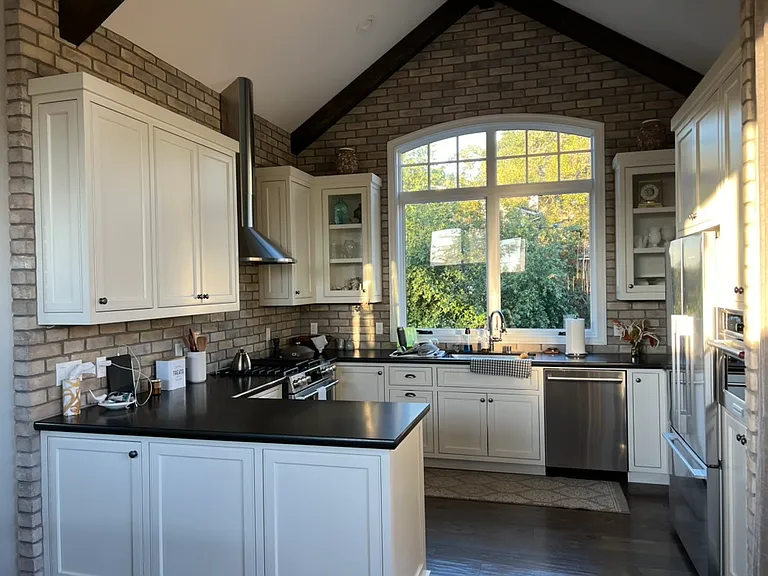 Gourmet Kitchen with vaulted ceiling, custom wood beams, and grand window overlooking Wissahickon and nearby mountains.
