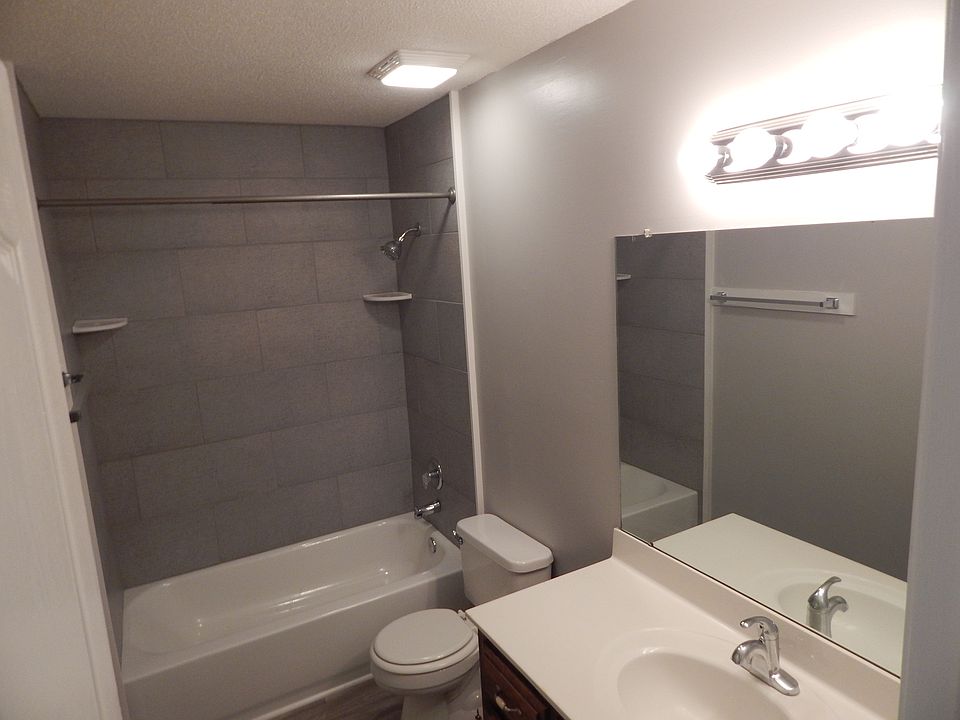 Updated bathroom features a steel tub with tile surround.