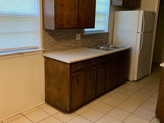 The Kitchen: Ceramic tiled flooring, wooden cabinets, and washer/dryer connections in room to the right of the kitchen