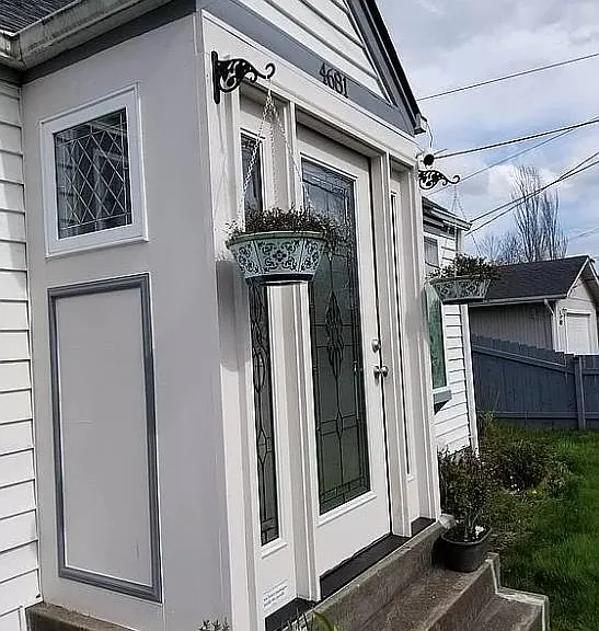 Enclosed front porch with crank-out windows at sides.