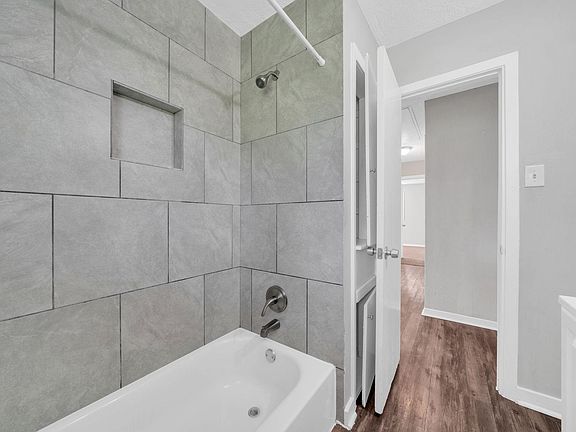 Full size bathroom with tub/shower and storage closet for personal items.