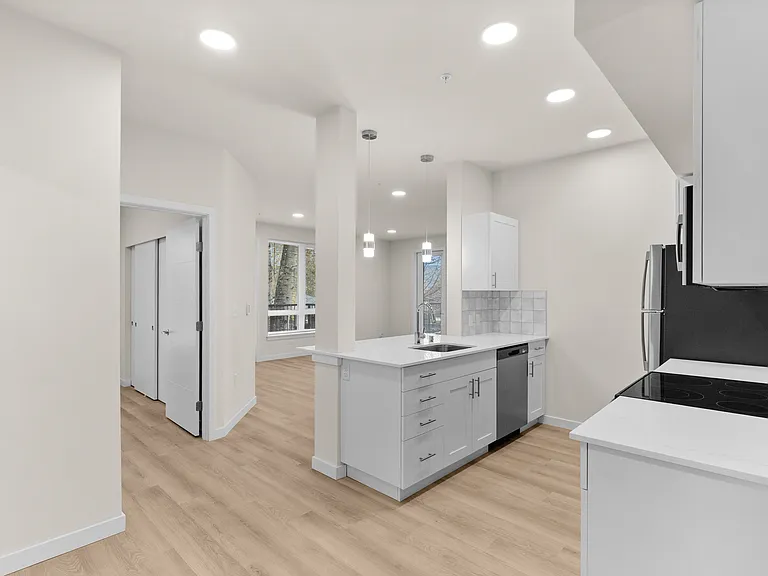 Modern staged kitchen featuring bright white storage, stainless appliances, and a sleek quartz-style island. Modern staged kitchen featuring bright white storage, stainless appliances, and a sleek quartz-style island.