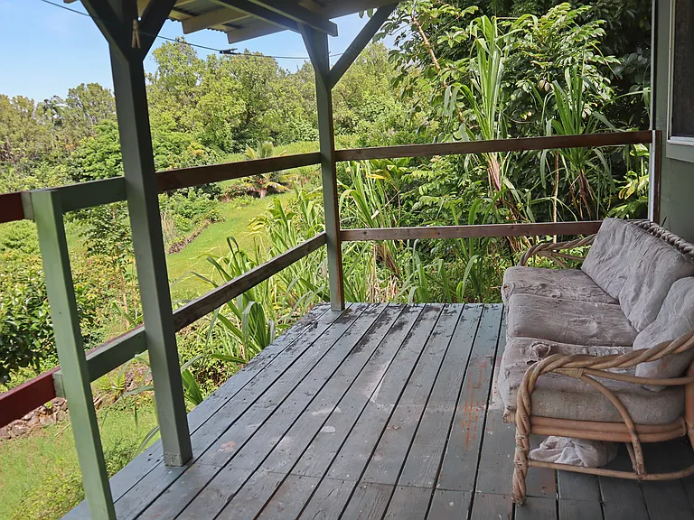Lanai outside the kitchen that overlooks the land. Great space for morning tea/coffee.
