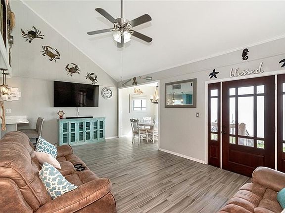 Living room with ceramic tile, high vaulted ceiling, baseboards, and a ceiling fan