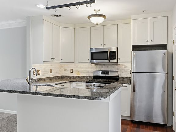 Stainless Steel, granite & and overhead pot holder in the beautiful kitchen.