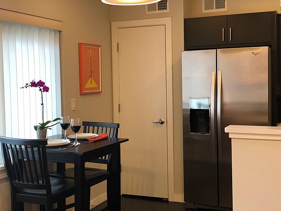 Cozy dining nook with large pantry closet next to refrigerator.