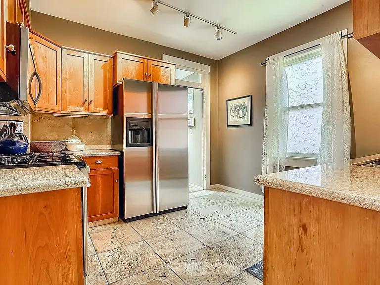 Remodeled kitchen with stone tile floor