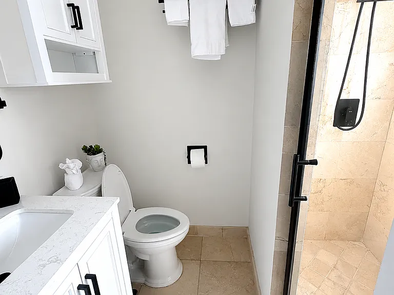 Fully renovated bathroom in the master bedroom - with modern finishes, clean design, fresh towels, and a comfortable setup for guests after a day at Naples Beach.